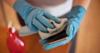 A woman cleans an phone.