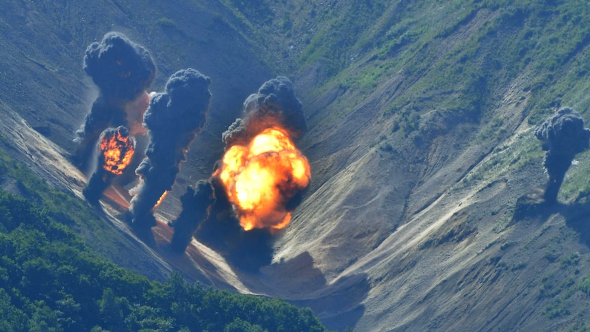 Bombs explode over a simulated target in the hills of South Korea.