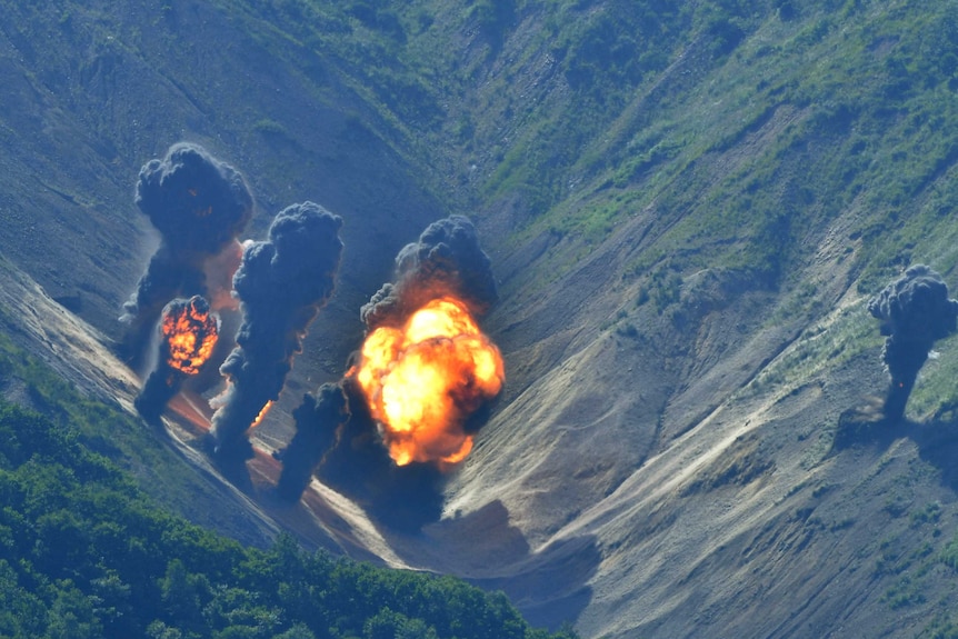 Bombs explode over a simulated target in the hills of South Korea.