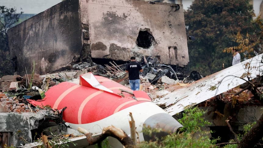 A firefighter stands next to the wreckage of the Air India Boeing 787-8 Dreamliner, in Ahmedabad, India.