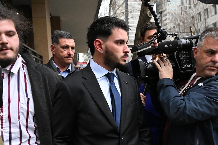 Alex Agelopoulos departs from the Melbourne Magistrates' Court, wearing a suit.