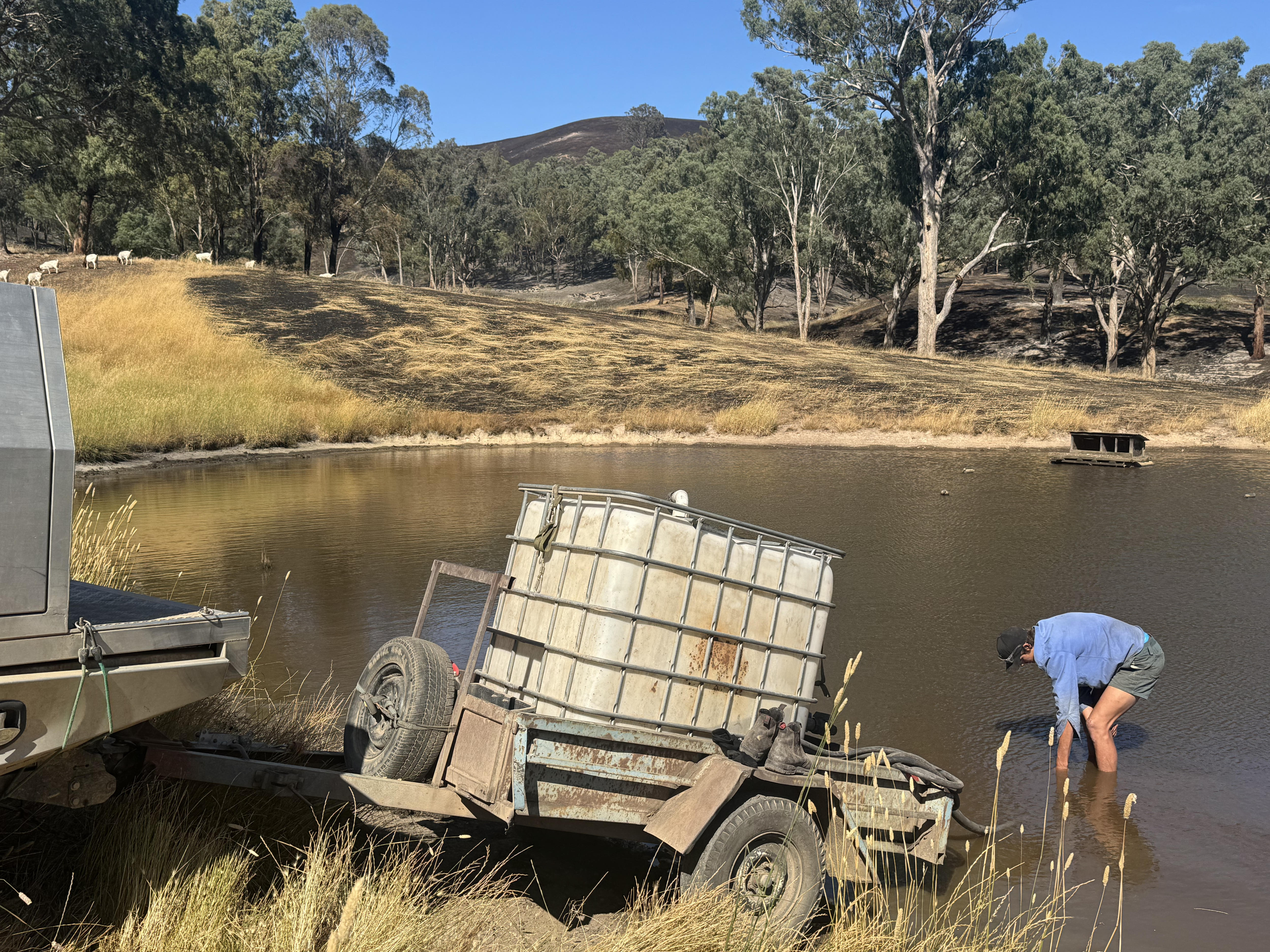 Bradley Irvine rellena un tanque de agua en una presa.