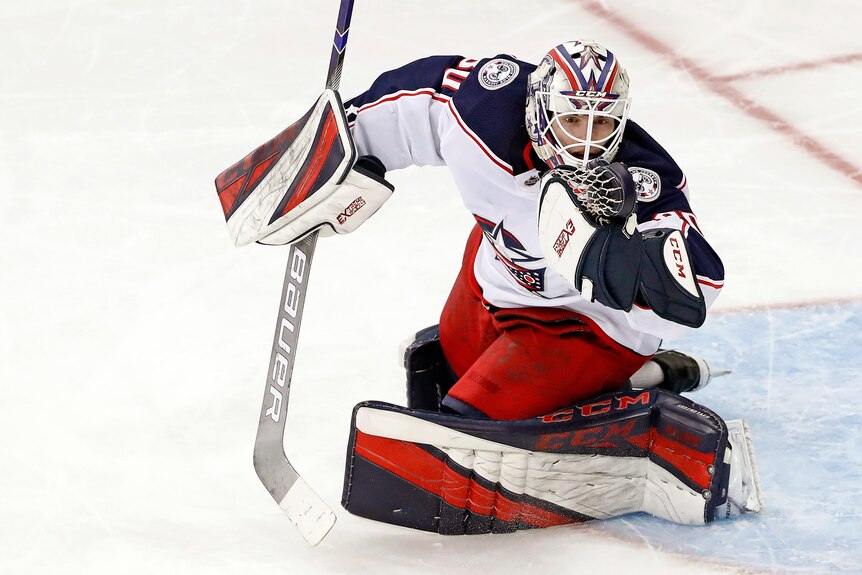 Matiss Kivlenieks (80) has the puck in his hand as he makes a save during the third period of an NHL hockey game.