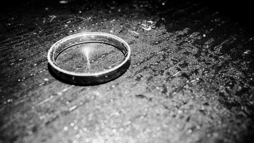 A black and white photo of a ring on a kitchen table.