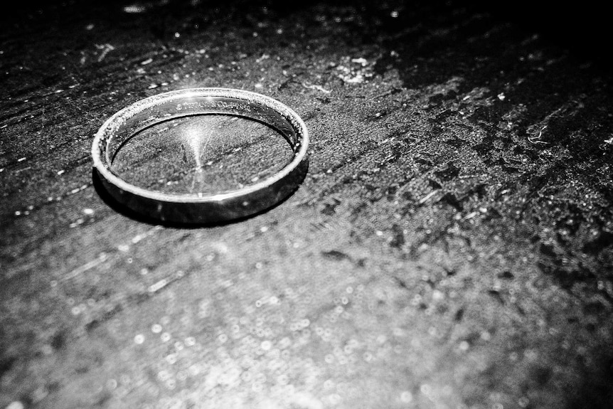 A black and white photo of a ring on a kitchen table.