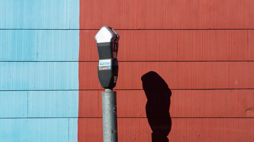 Parking metre against a blue and red background.