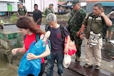 Two BBC journalists being escorted out of Papua by military personnel