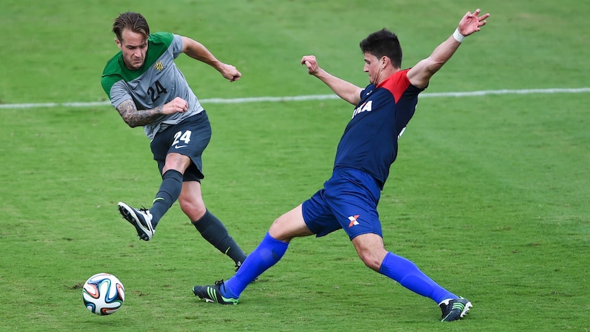 The Socceroos' Adam Taggart fights for the ball against Brazilian side Parana Clube in Vitoria