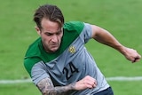 The Socceroos's Adam Taggart (L) fights for the ball during a training match against Parana Clube.