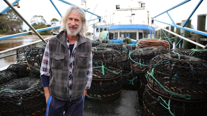 A smiling Garland, standing on a boat with hands in pocket.