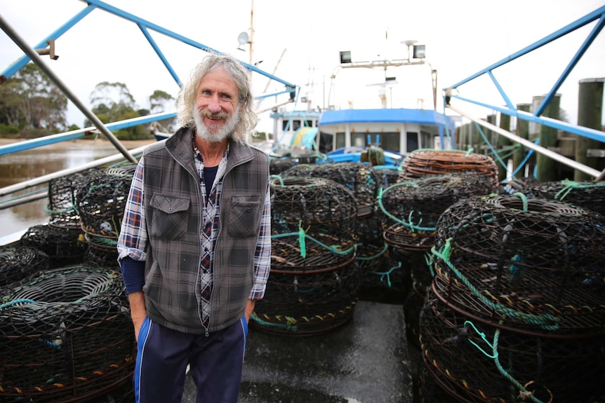 A smiling Garland, standing on a boat with hands in pocket.