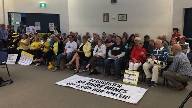 People sitting in protest at the new MidCoast council's first meeting