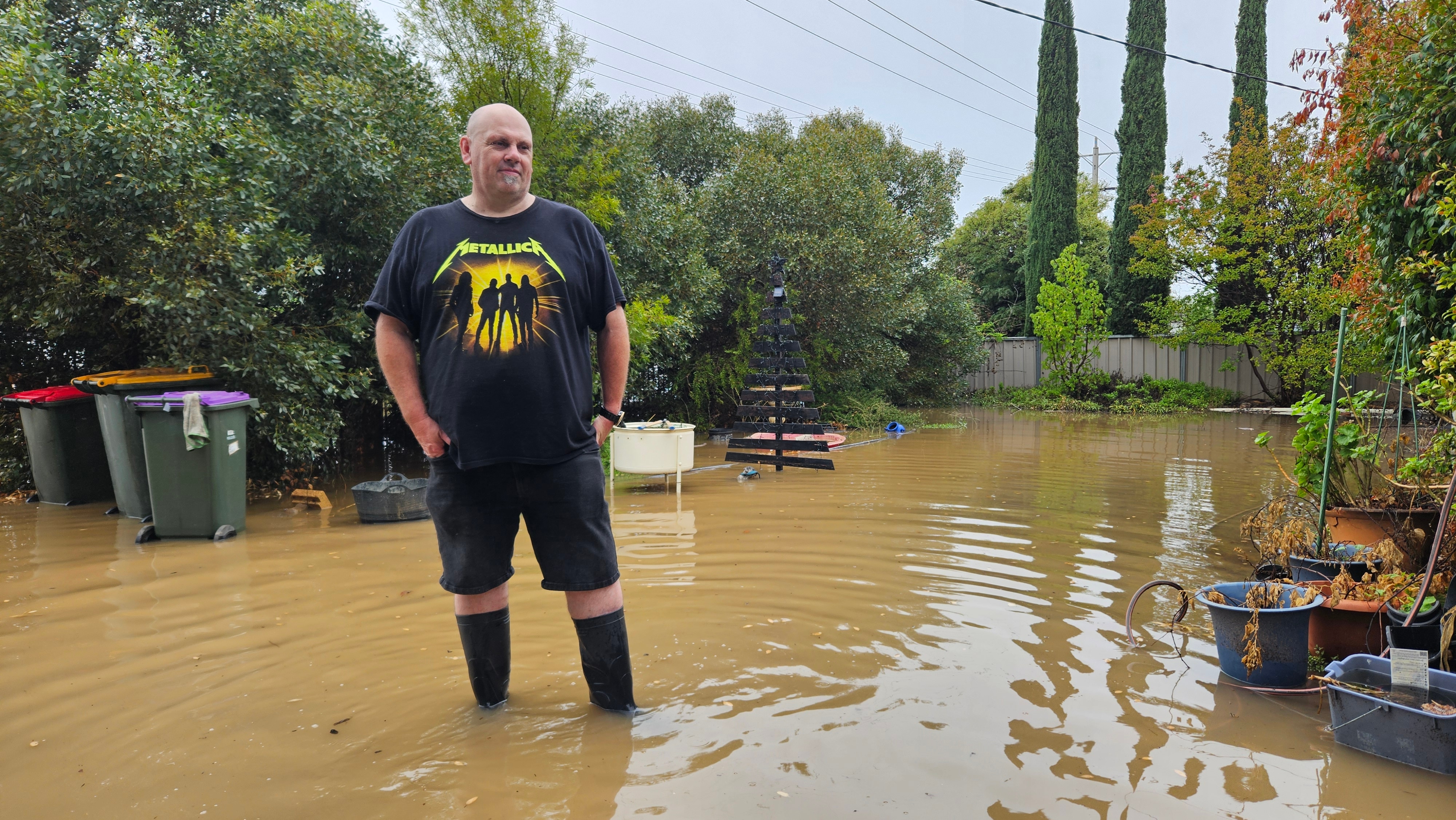 Brett standing in floodwaters wearing gumboots.