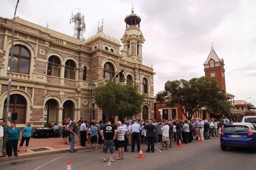 Locals gather outside the Broken Hill Town Hall to hear the announcement.