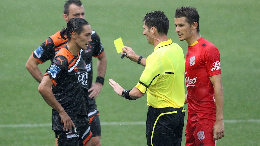 Issey Nakajima-Farran of the Roar receives a yellow card during the round 14 A-League match against the Brisbane Roar at Hindmarsh Stadium on January 7, 2012