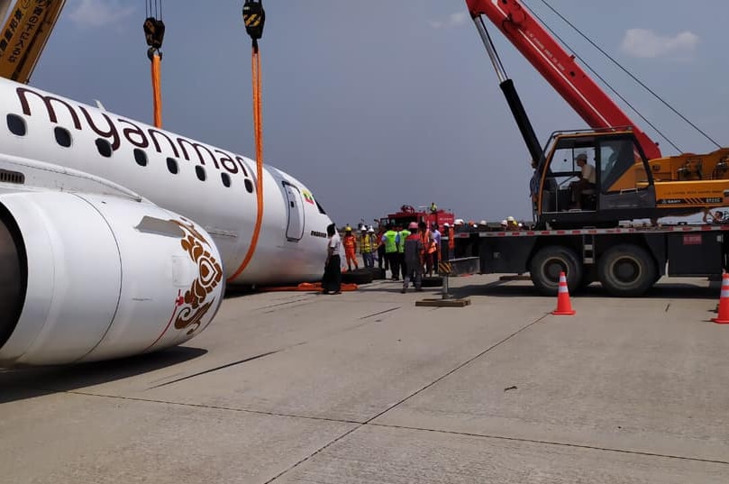 An airplane is hoisted by a crane after making an emergency landing at Mandalay International Airport.