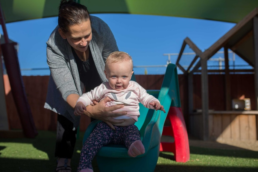 Miranda Edwards helps a child on the slide at Lulla's Children and Family Service in Shepparton, north-eastern Victoria.