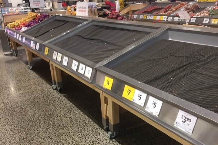 Fresh food shelves aisles are almost completely empty in a supermarket.