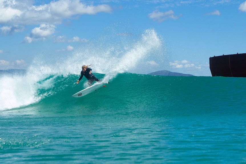 A man surfs on a large wave