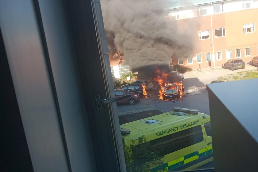 A car on fire in the carpark of a hospital in Liverpool.