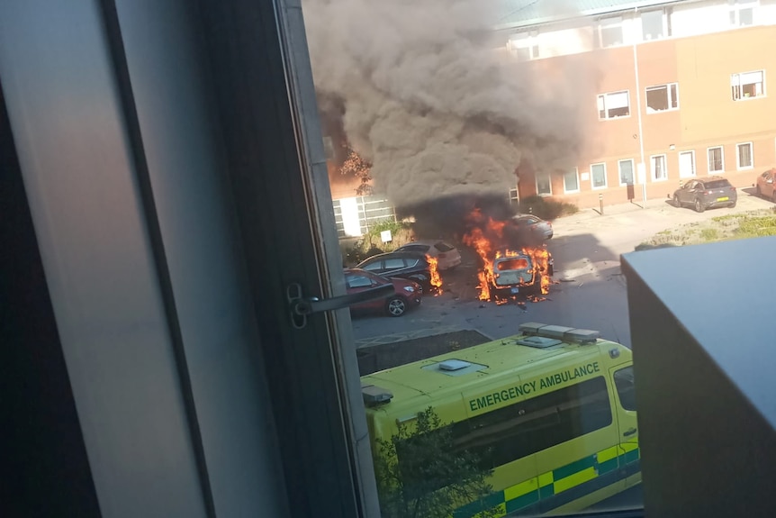 A car on fire in the carpark of a hospital in Liverpool.