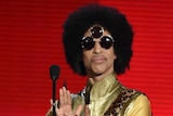 Prince speaking onstage during the 2015 American Music Awards