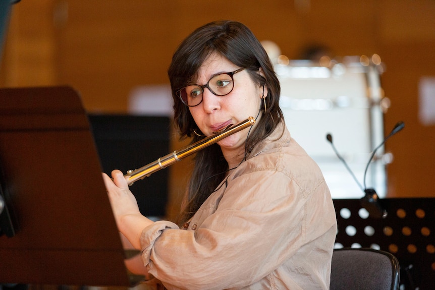 A woman plays the flute.