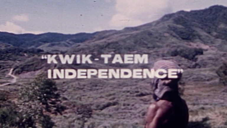 A man wearing a head covering looks out across a valley from a high mountain in PNG with 'Kwik Taem Independence' text overlaid
