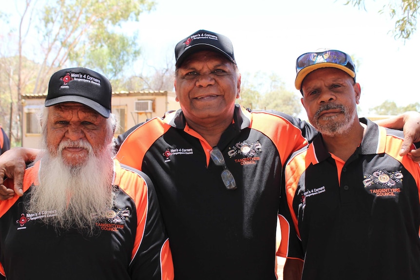 Geoffrey Shaw, Baden Williams, and Phillip Miller stand with their arms around each other