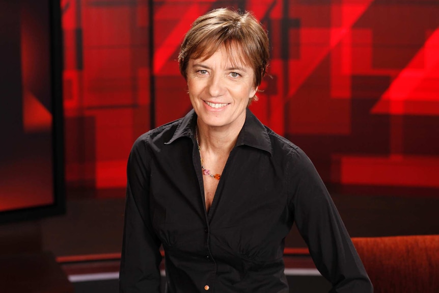 Liz Jackson smiles at the camera in front of four corners background.