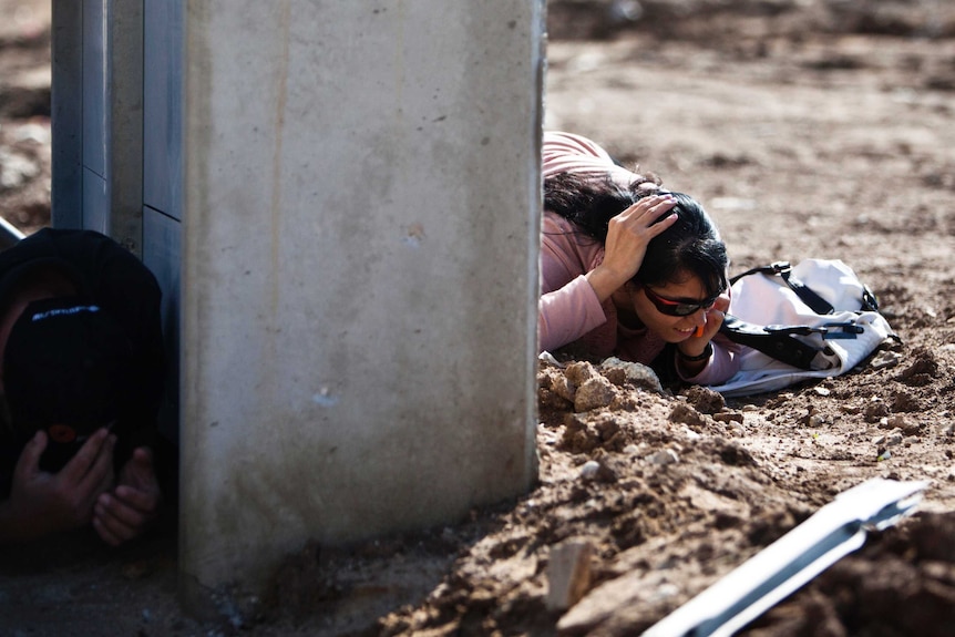 Israelis take cover as a siren sounds warning of incoming rockets in the southern town of Kiryat Malachi, November 15, 2012.