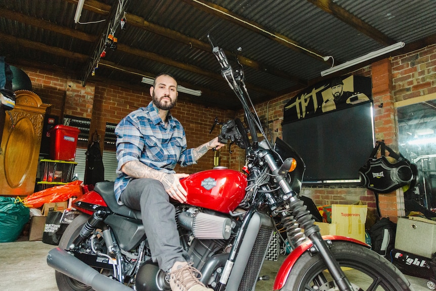 A man sits atop a motorcycle.