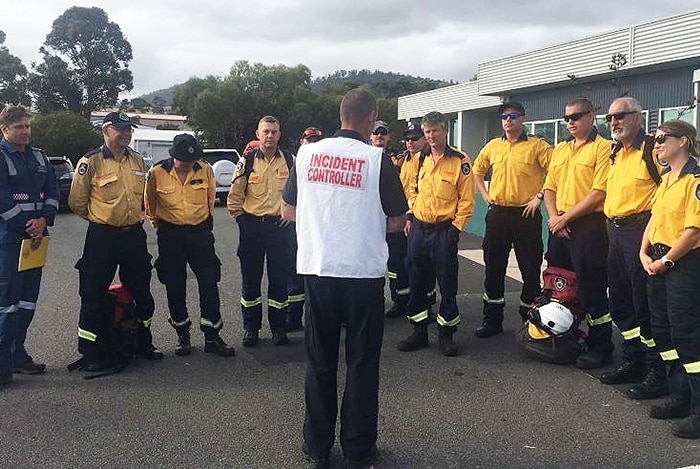 NSW firefighters get a briefing from the incident controller before heading to the Gell River fire front.