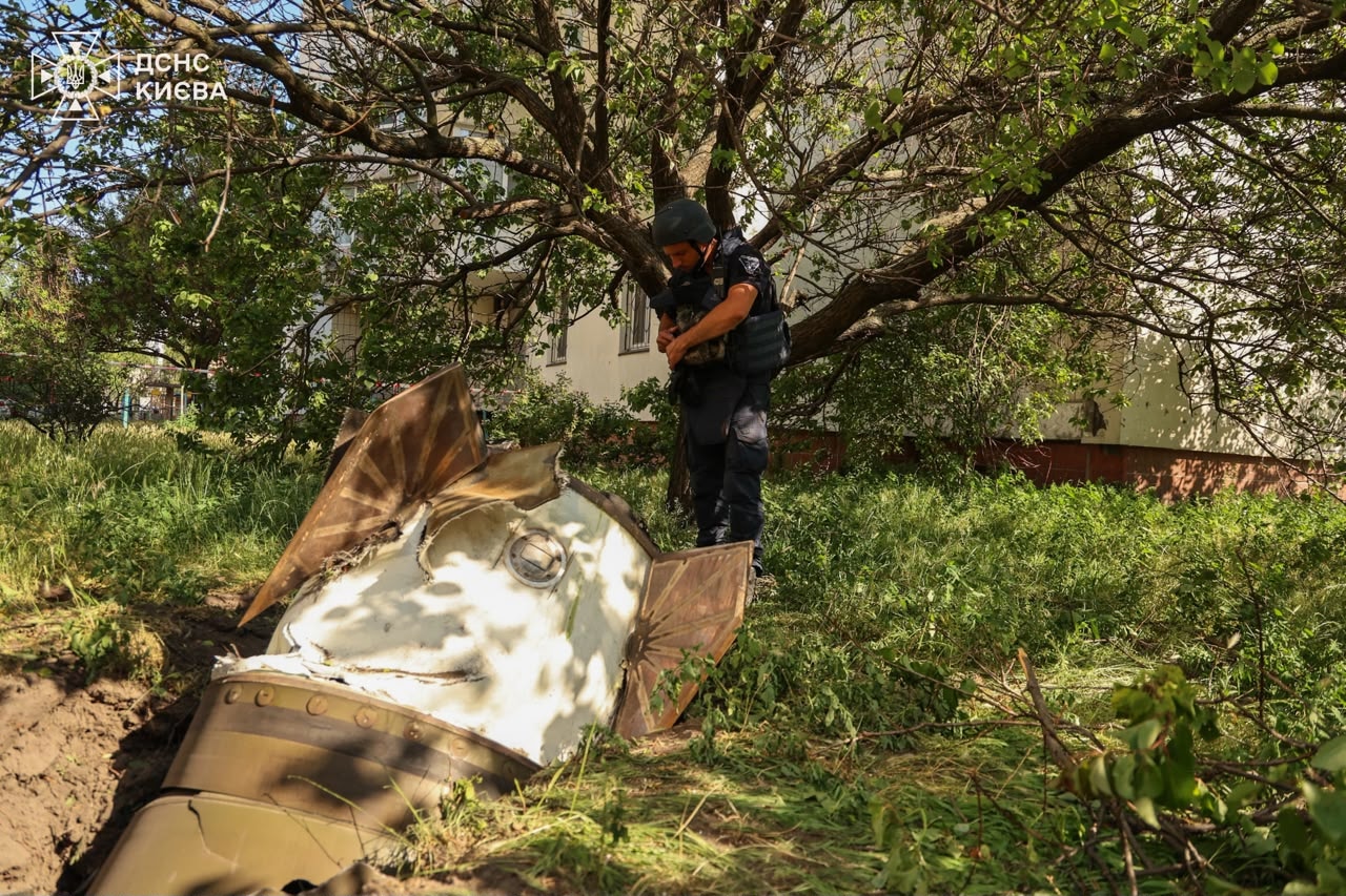 A sapper examines a fragment of the Russian missile in a residential neighbourhood following an air attack in Kyiv