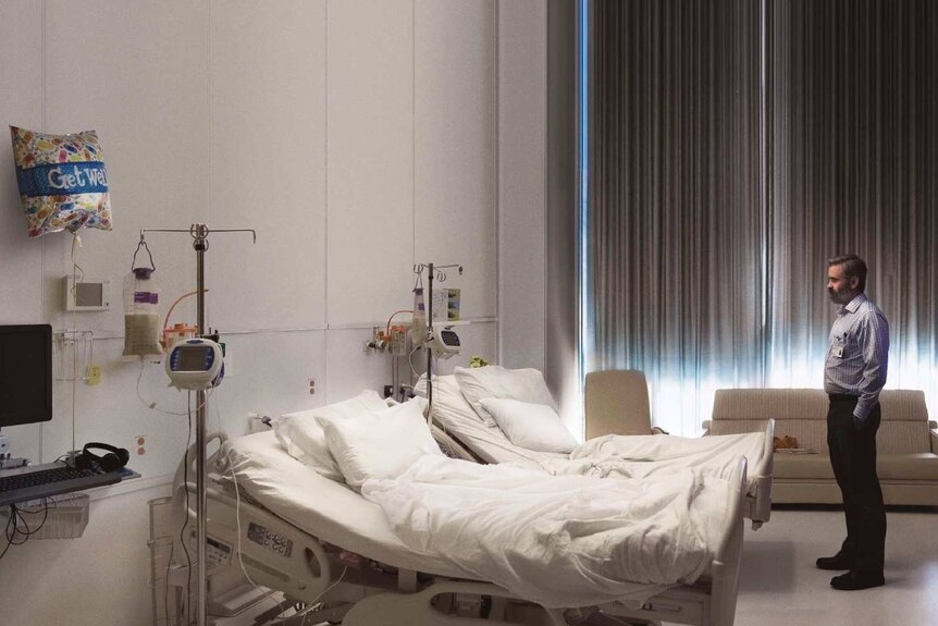 Colin Farrell stands facing an empty hospital bed in the poster for 2017 film The Killing of a Sacred Deer.