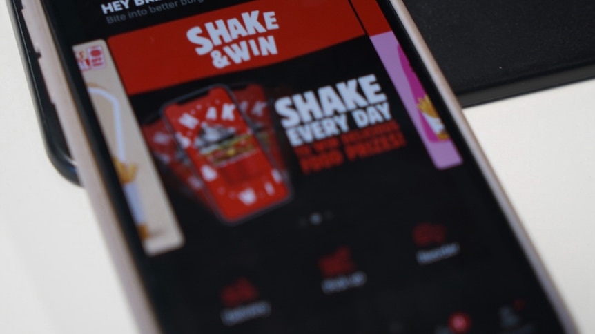 A close up of an app with shake and win written on red, white and black bright colourful background.