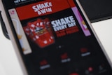 A close up of an app with shake and win written on red, white and black bright colourful background.