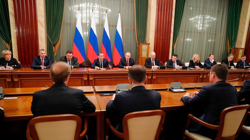 Russian President Vladimir Putin, center, and Russian Prime Minister Dmitry Medvedev, center left, attend a cabinet meeting.