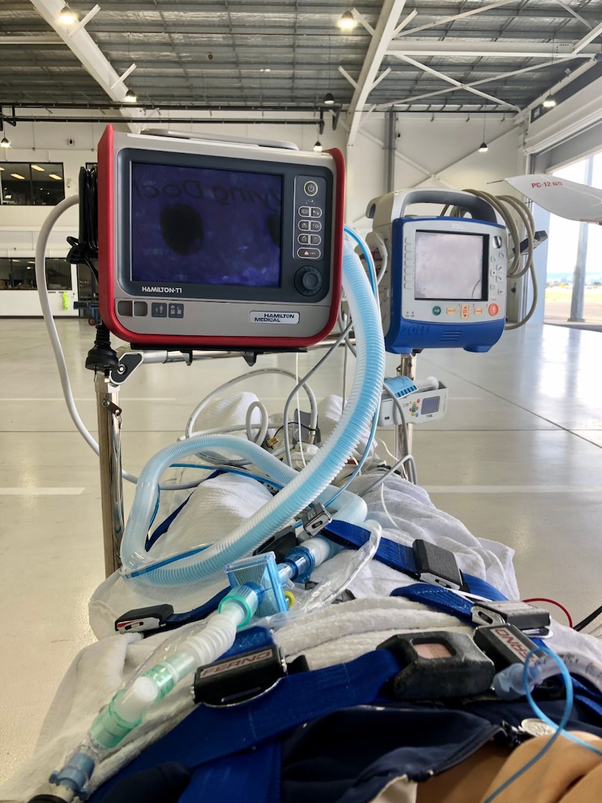 A portable ventilator strapped to a stretcher.
