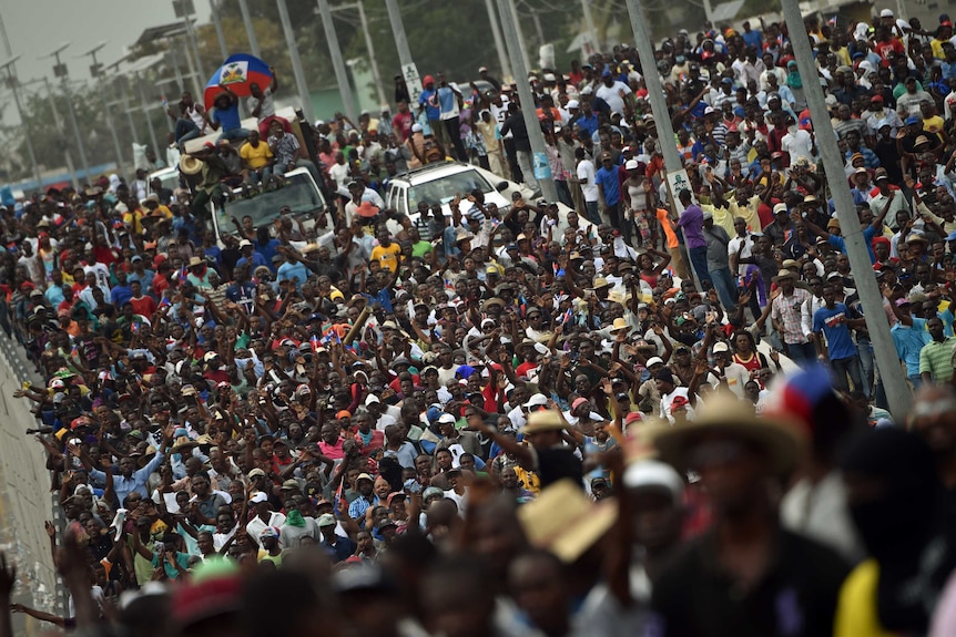 A crowd of hundreds of demonstrators march through the streets of Port-au-Prince, Haiti.