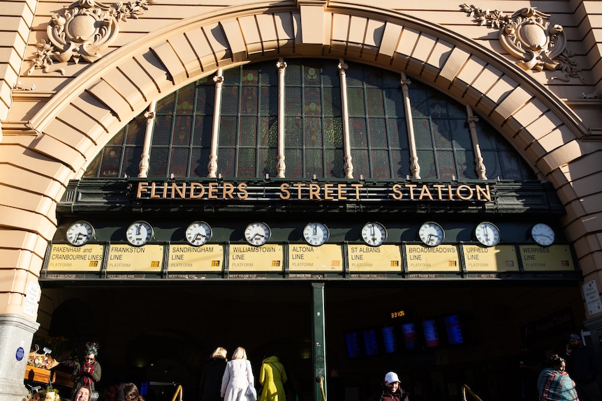 Nine analog clock faces show the times of upcoming trains at Melbourne's Flinders Street Station