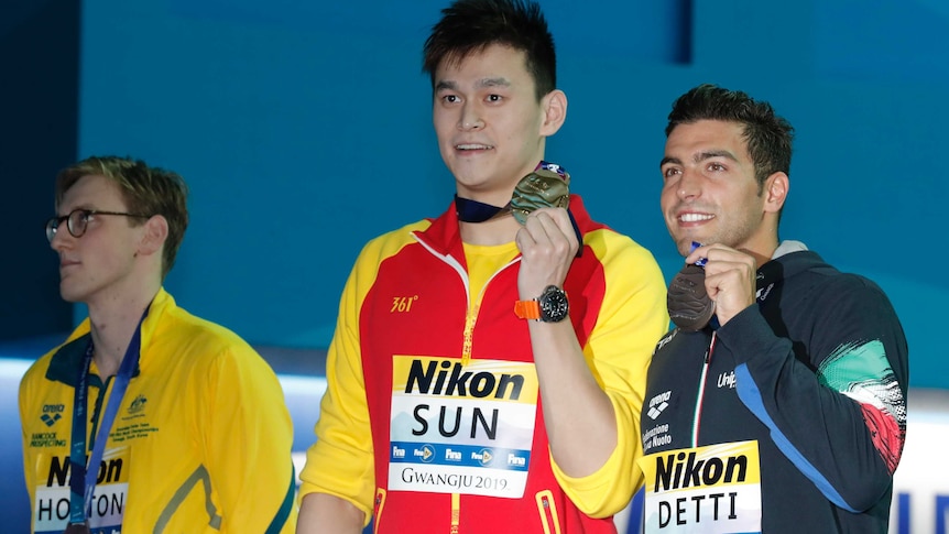 Australian swimmer Mack Horton (left) looks elsewhere while Sun Yang and Gabriele Detti hold up their world championship medals.