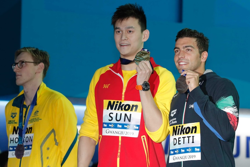 Australian swimmer Mack Horton (left) looks elsewhere while Sun Yang and Gabriele Detti hold up their world championship medals.