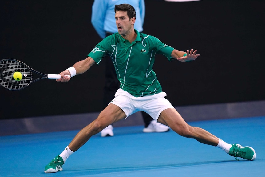 A tennis player skids to the side to get a forehand return away in the Australian Open final.