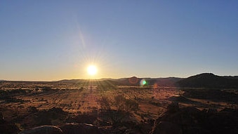 Sunset over the red dust near Nyapari in South Australia's Anangu Pitjantjatjara Yankunytjatjara lands (Marky/ABC Contributor)