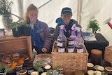 two young school kids, one girl and one boy sitting behind their stall selling chutney and jam to raise money 