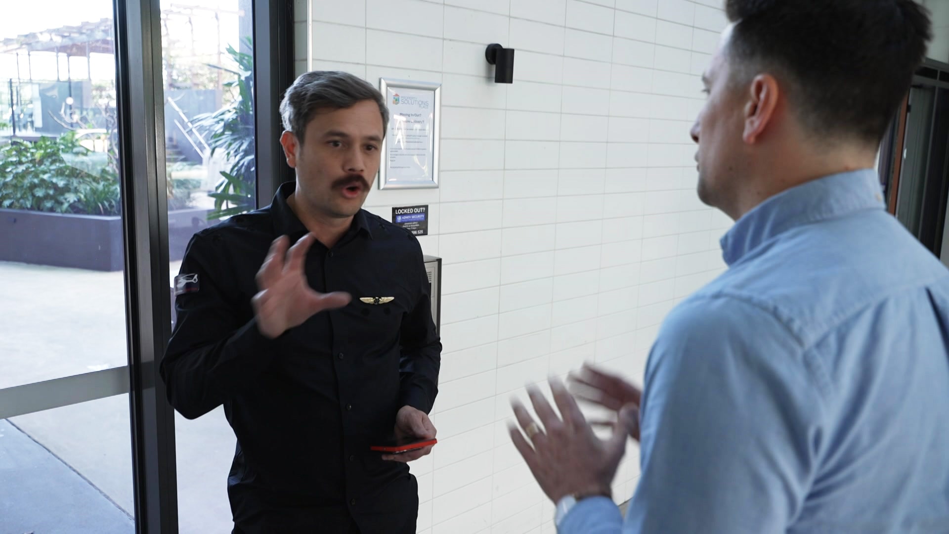 A man speaks with his hands to another man.