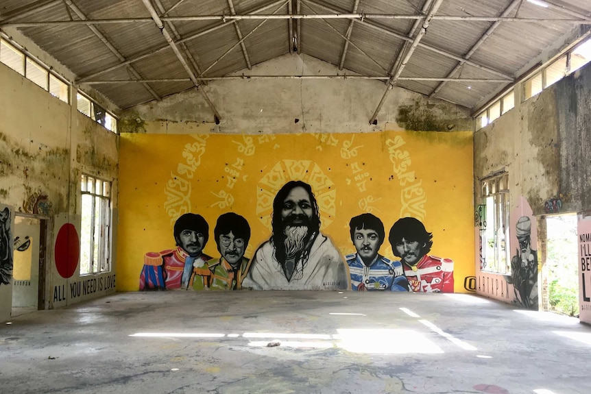A mural showing the beatles on a dilapidated wall