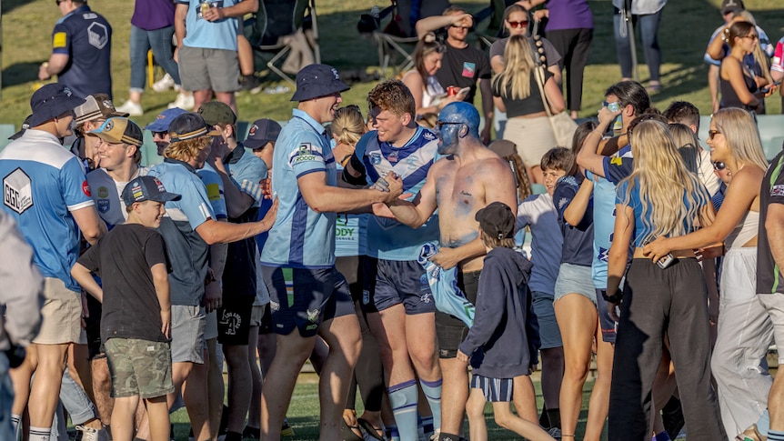 A group of fans celebrate winning a rugby league match