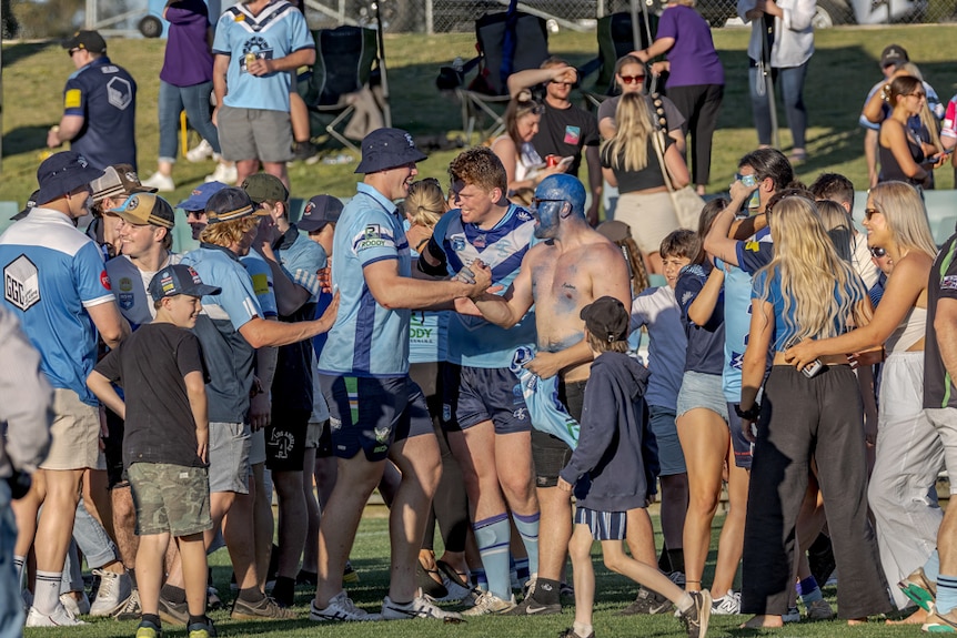 A group of fans celebrate winning a rugby league match